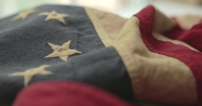 American flag detail with red and white stripes with field of blue and circle of 13 stars, the flag designed by Betsy Ross during the American Revolution. Shot in cinematic 4K.