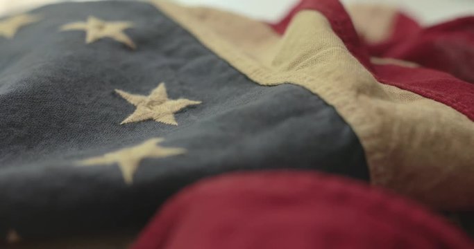 American flag detail with red and white stripes with field of blue and circle of 13 stars, the flag designed by Betsy Ross during the American Revolution. Shot in cinematic 4K.