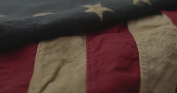 American flag detail with red and white stripes with field of blue and circle of 13 stars, the flag designed by Betsy Ross during the American Revolution. Shot in cinematic 4K.
