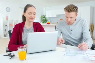 Obraz na płótnie Canvas young couple at home using a laptop
