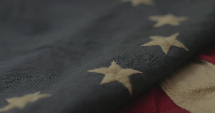 American flag detail with red and white stripes with field of blue and circle of 13 stars, the flag designed by Betsy Ross during the American Revolution. Shot in cinematic 4K.