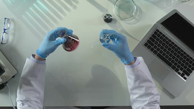 Lab assistant conducting investigations for presence of sediments in liquid