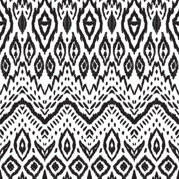 Abstract background. Black and white Ikat seamless pattern for textile, wallpaper, card or wrapping paper. © aunaauna