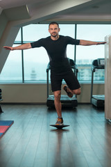 Young Man Doing Exercise On Bosu Balance Ball