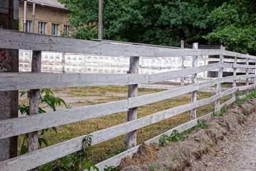 серый сельский деревянный забор вдоль пустого двора