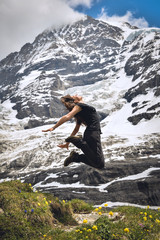 Happy girl jumping, beautiful landscape in Swiss Alps