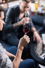 Skilled sommelier pouring wine. Man in black suit and white shirt looks concentrated: he's evaluating quality of wine being pouring. Process of tasting wine captured in photo.