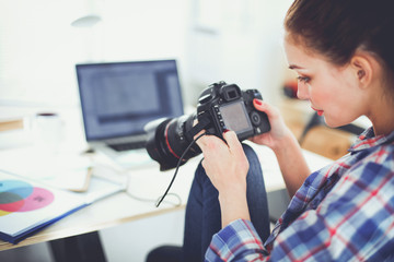 Female photographer sitting on the desk with laptop