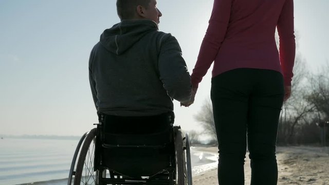 disabled love, invalid person with girl, couple of lovers, on wheel chair, happy cripple on wheelchair, male handicapped faith in future, self-confidence in human, outdoors near river,