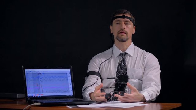 A man doubting and fidgeting when answering polygraph questions.