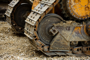 Fototapeta na wymiar The Crawler close up , muddy crawler chain detail in earthy ambiance, Well used excavator tracks closeup