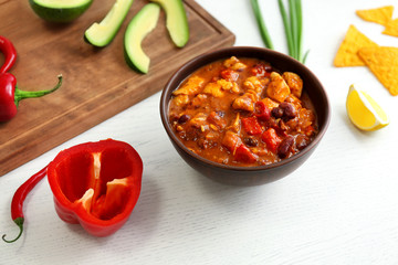Delicious chili turkey, fresh vegetables and nachos on table