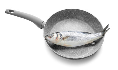 Frying pan with raw fish on white background