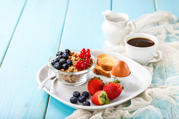 Breakfast - muesli, berries and coffee. Selective focus. Copy space