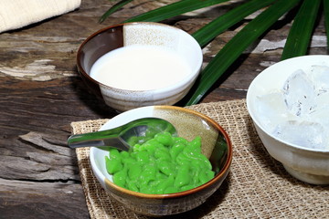 Lod Chong, Thai dessert, rice noodles made of rice eaten with coconut milk on wooden table background, Dark or Classic Tone.
