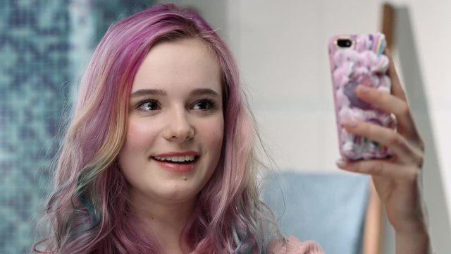 Young woman is taking photos of her new hairstyle for her friends
