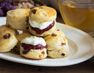 Homemade raisin scones serve with homemade strawberries jam,clotted cream and tea.Scones is English pastry for afternoon tea,cream tea.Delicious scones Devon shire or Cornish cream style.