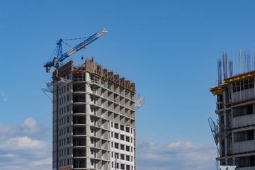 Fototapeta na wymiar Construction of a house in the city. Cranes build a skyscraper