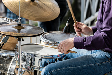 hands of musician while playing drums during street concert closeup