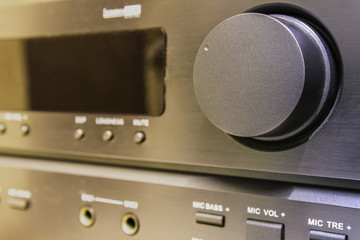 Close-up of a black audio amplifier, focusing on the control knobs and buttons, showcasing the...