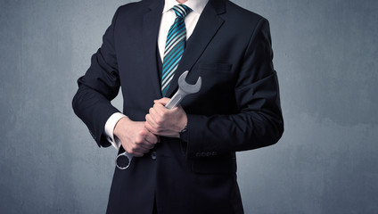 Businesman standing with tool on his hand