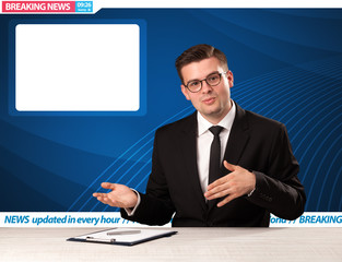 Television reporter telling breaking news at his studio desk with copy space