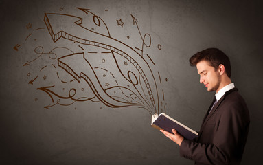 Young man holding book with arrows