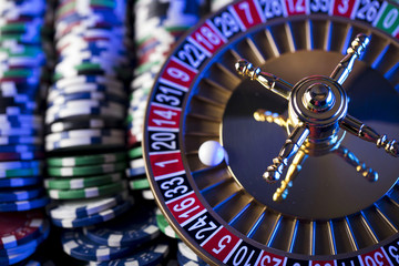 Casino blurred background. Roulette and stacks of chips.