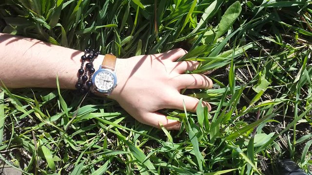 Hand with a clock on the grass