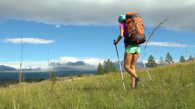 Hiking woman tourist is walking mountain range