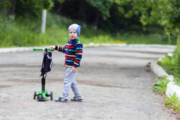 The boy walks on the street and skates on the samovette. Happy childhood