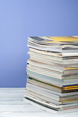 Open stacking book, hardback colorful books, magazine on wooden table and purple background. Back to school. Copy space for text. Education business concept.