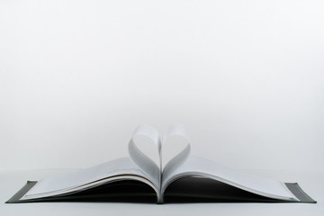Old open hardback book, page decorate into a heart shape for love in Valentine's. love with open book heart.