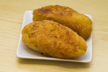 Croquettes on the plate on wooden table