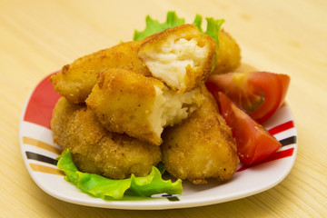 Croquettes with lettuce and tomato on wood