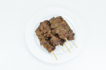 Grilled pork with bamboo stick in white dish on white background,Thai styled grill pork barbeque