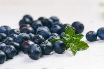 Fresh blueberries with mint on a wooden white table. Natural antioxidant. Concept of healthy food. Organic superfood