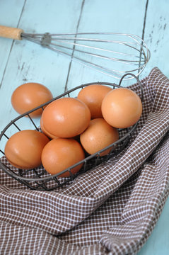 Fresh Eggs with Whisk put on Background
