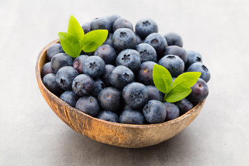 Fresh blueberries natural coconut in a bowl on a gray background.