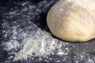 Pizza Dough Baking on Dark Black Background. Baking bread, pizza, pasta. Recipe from chef cooks pizza. Italian home cooking.Сulinary Сoncept