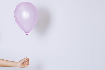 Womans hand holds balloons in a white background