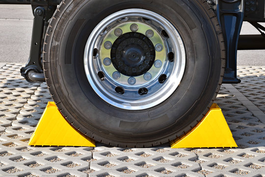 Yellow chocks at the wheel of a parked truck