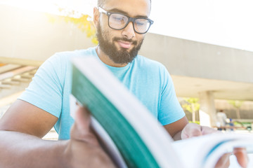 Black man reading a book in the city