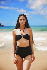 Bikini model girl posing sexy at tropical beach location. Vogue style