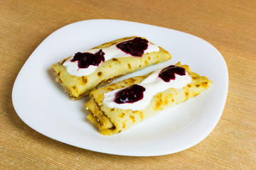Pancakes with cottage cheese, fruit jam and cream.