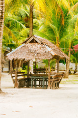 Landscape of paradise tropical island with palms, cottages and white sand beach in Asia