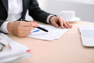Business woman sitting at the table and examines the financial results
