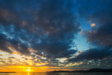 Obraz premium Dark clouds over the sea at sunset