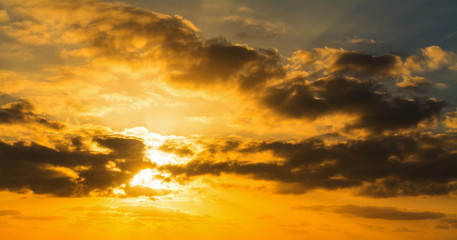 Dark clouds and bright sun at sunset
