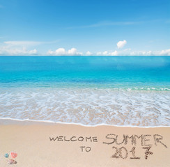 Fototapeta na wymiar welcome to summer 2017 written on a tropical beach